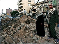 Lebanese women inspect a road in the city of Tyre, after it was hit by an Israeli missile strike