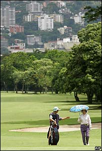 A golfer and caddy at Caracas Country Club