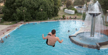 A US soldier jumps from a platform as he enjoys Saddam Hussein's swimming pool at the Republican Palace